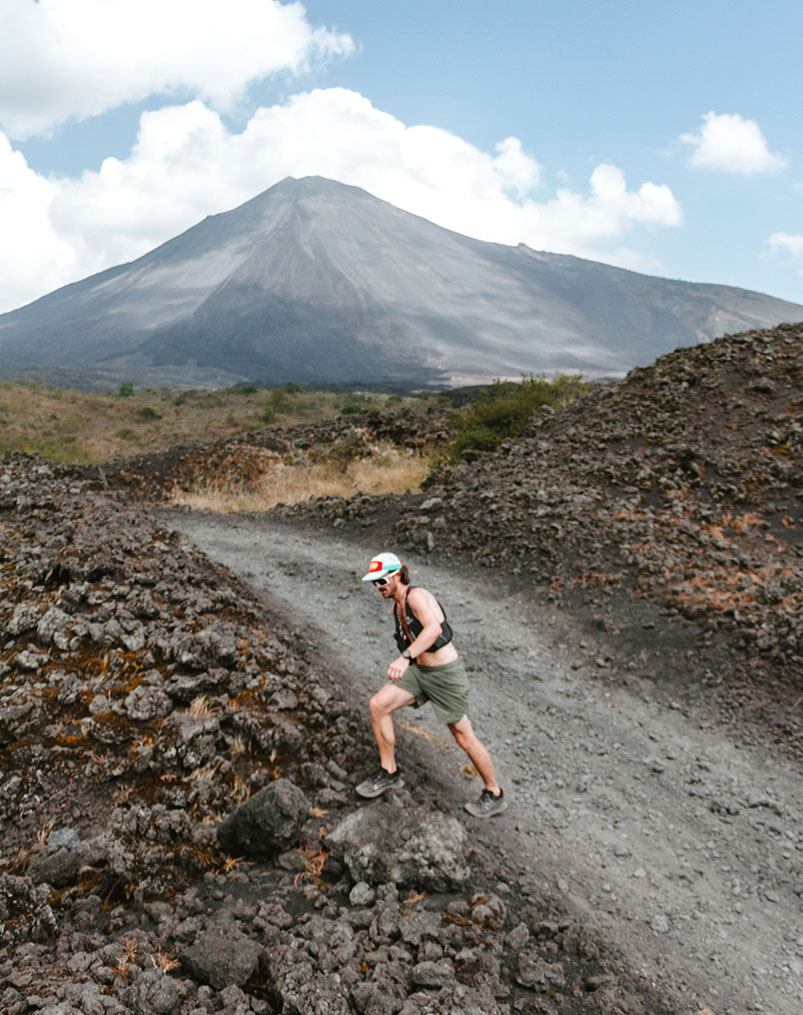 Runner on volcanic sand below a volcano in Guatemala