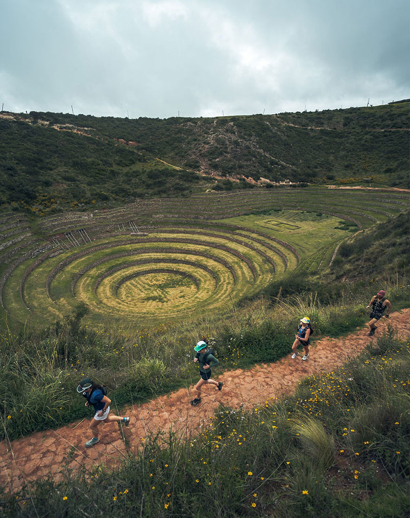 Runners on a trail above the Moray terraces in the Sacred Valley, Peru